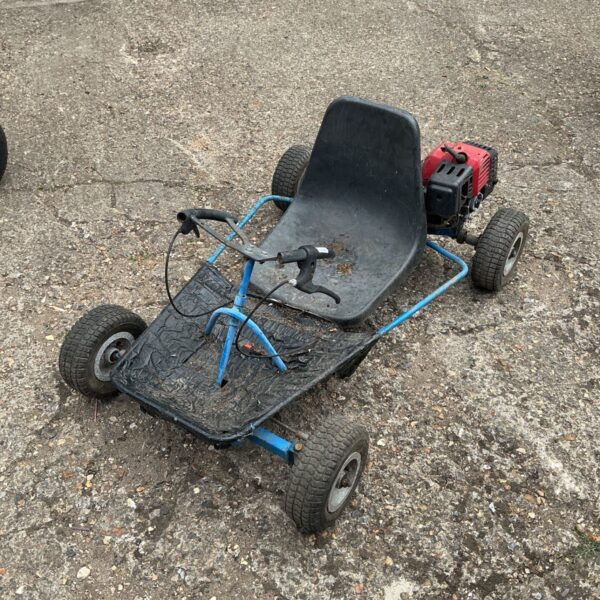 Vintage petrol go kart chassis with engine, ready for restoration.