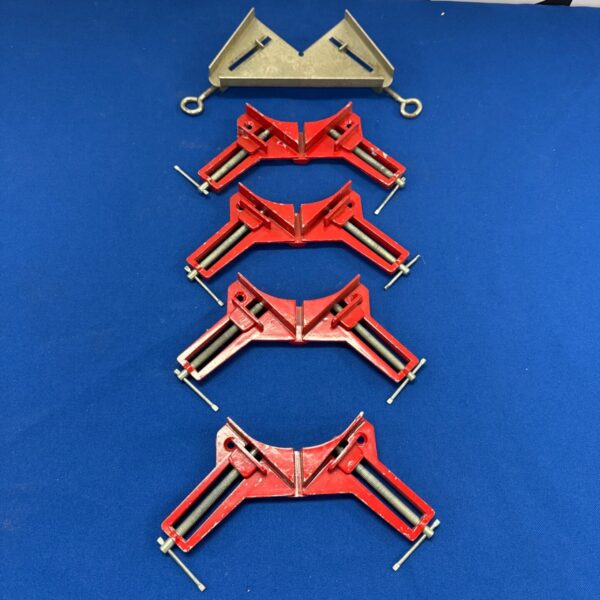 Set of four red handled picture framing clamps for woodworking.