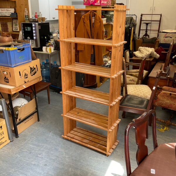 Rustic pine shelving unit with five tiers for storage.