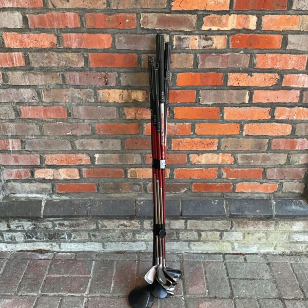 Ping G20 golf clubs leaning against a brick wall.