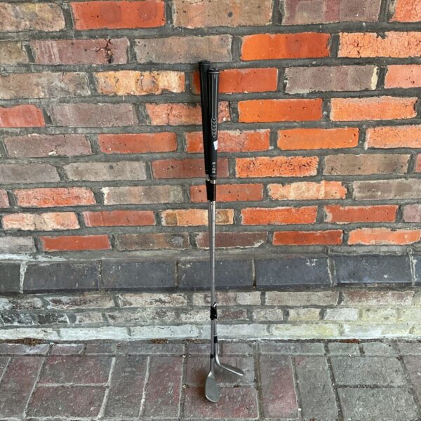 Vintage Ping Gorge Tour wedge leaning against brick wall.