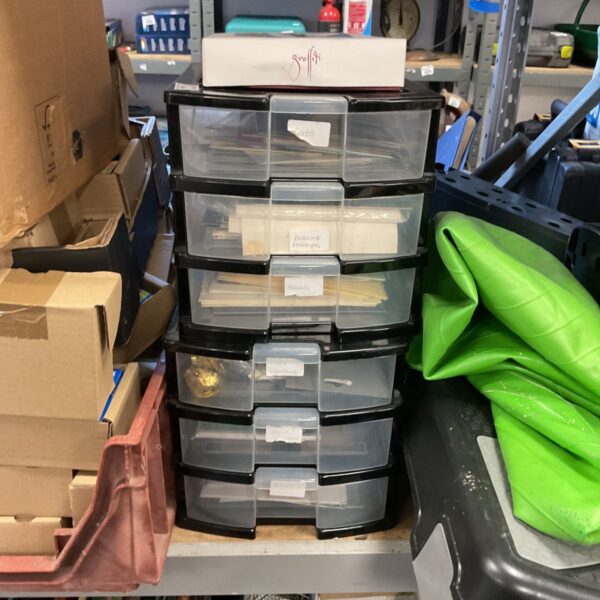 Plastic storage shelves filled with envelopes and cards for organisation.