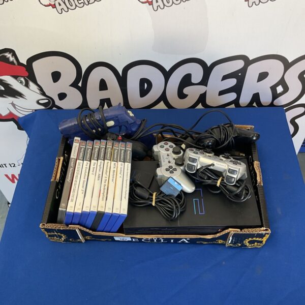 Vintage PlayStation 2 console bundle with controllers and gun.
