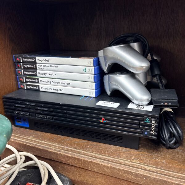 Sony PlayStation 2 console with games and controllers displayed.