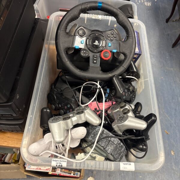PlayStation controllers and Logitech steering wheel in a box.