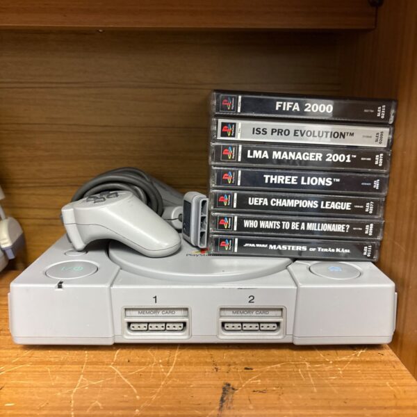 Sony PlayStation One console with games and controller.