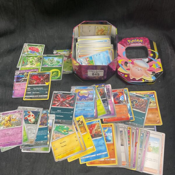 Colorful Pokemon card tin with assorted trading cards inside.