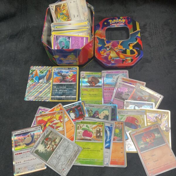 Assorted Pokemon cards inside a tin, collectible trading card game.