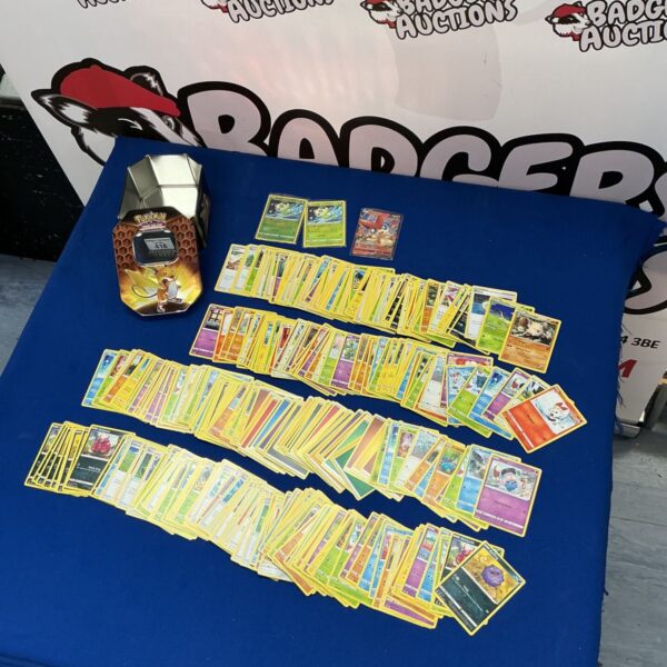 Large lot of Pokémon trading cards inside a collector's tin.
