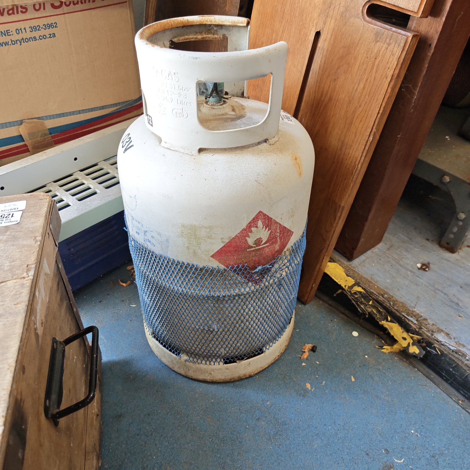Empty 12.9kg propane gas bottle for outdoor use.