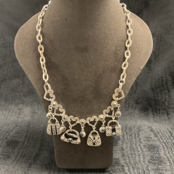 Silver-tone purse charm necklace with crystal details.
