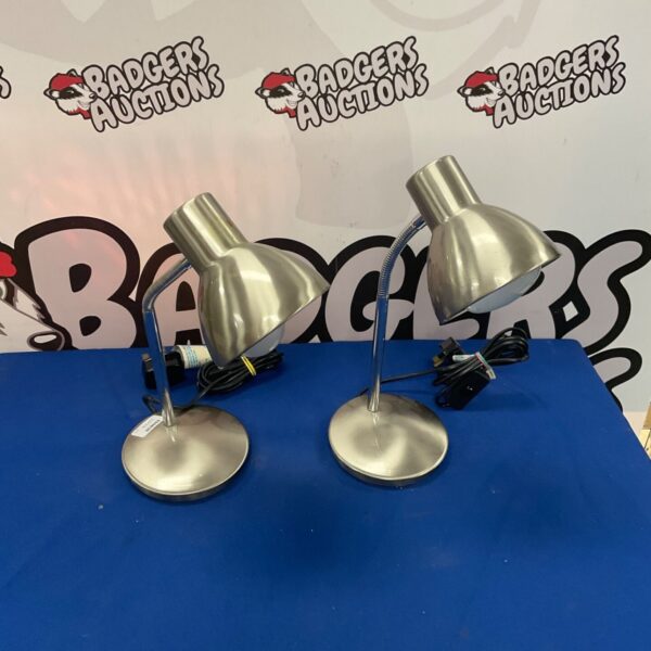 Two brushed metal flexible reading lamps on a surface.