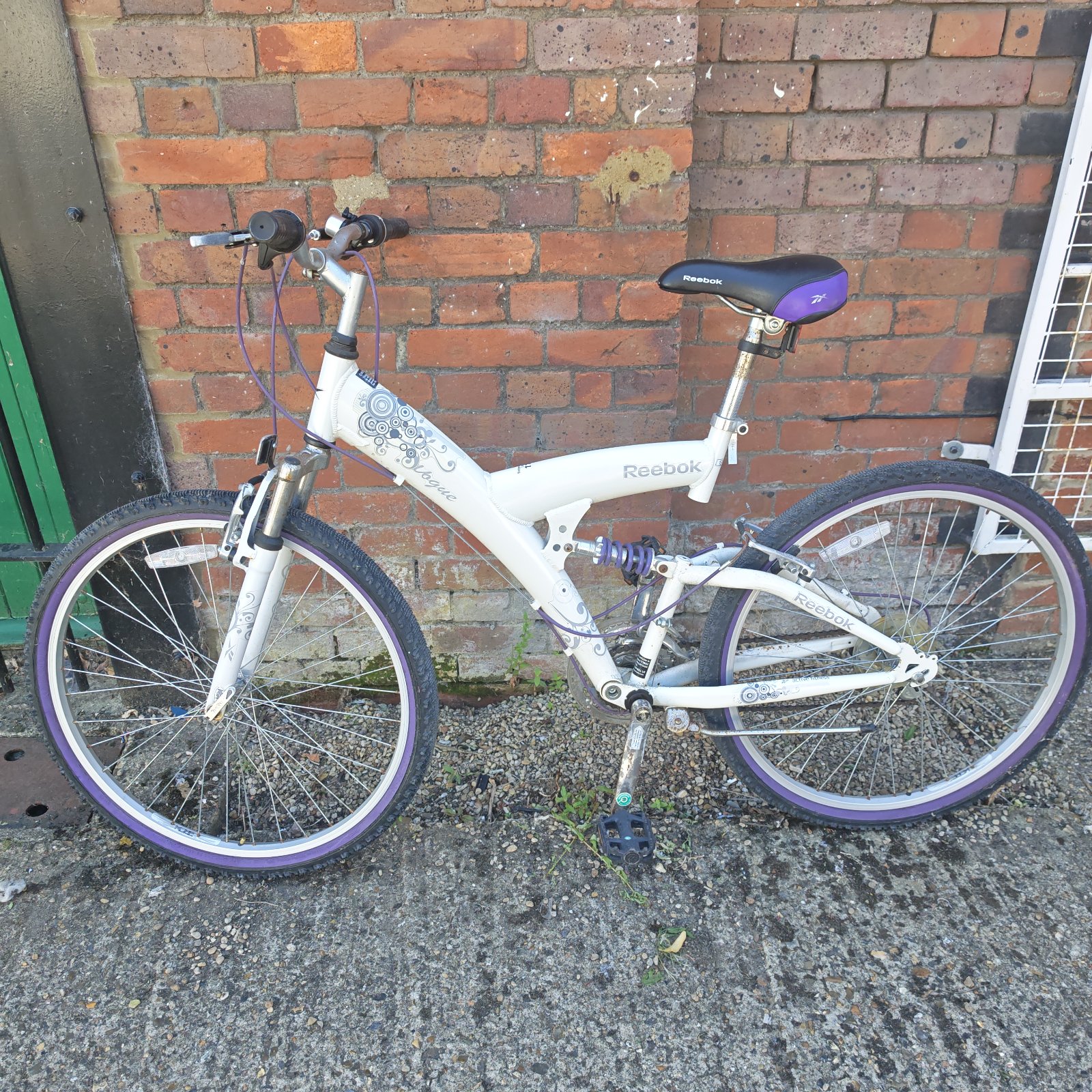 Purple Reebok girls mountain bike with front suspension.