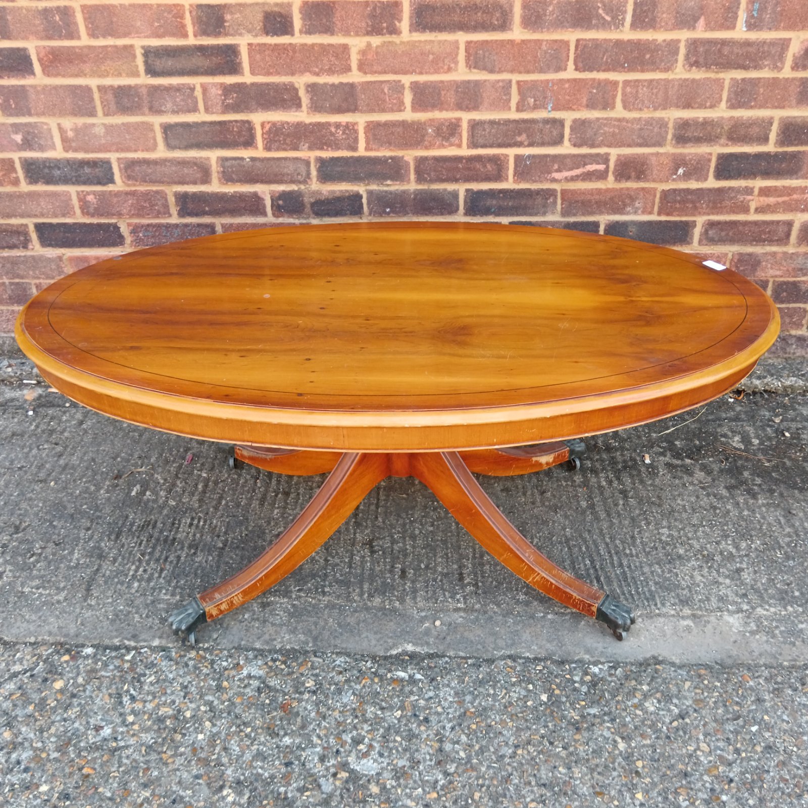 Vintage Reprodux yew wood coffee table with claw feet.