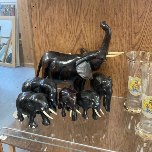 Dark resin elephant figurines arranged as a herd, decorative home accent.