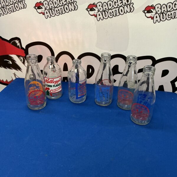 Retro milk bottles with colourful vintage advertisements for collectors.