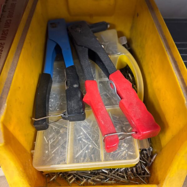 Two used rivet guns with a supply of rivets for metal fastening.