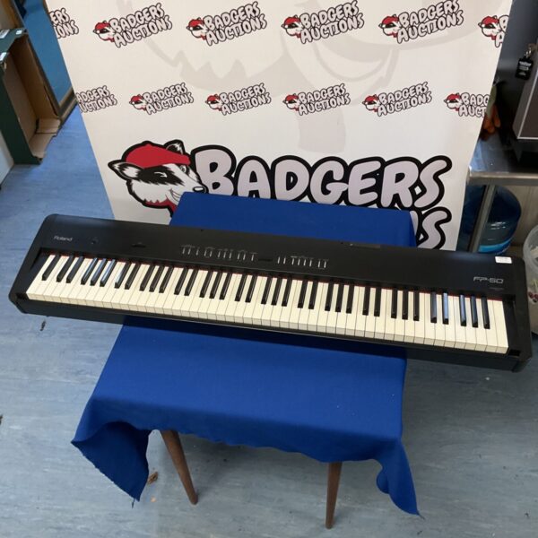 Roland FP-50 digital piano on a table, showing the keys and controls.