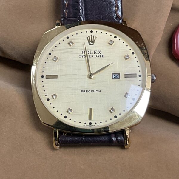 Close-up of vintage Rolex Oysterdate wristwatch gold dial.