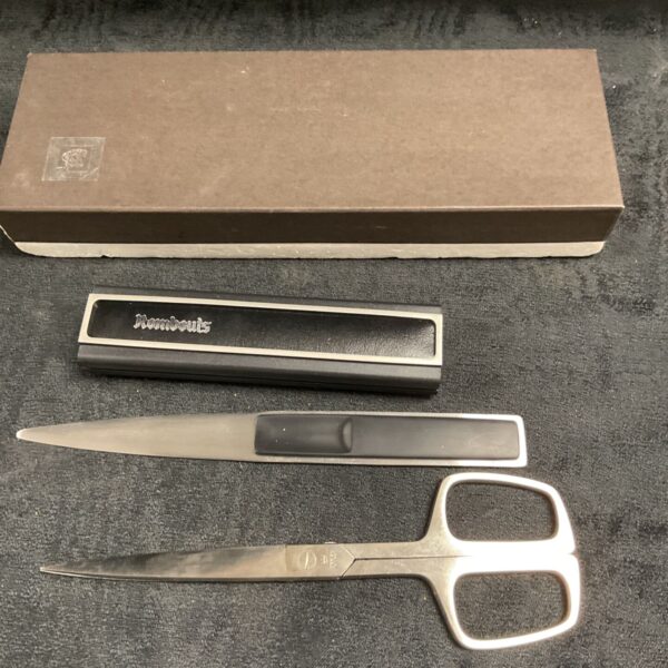 Vintage Rombouts desk set with letter opener and scissors on black background.
