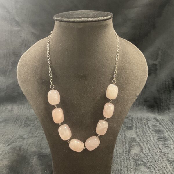 Polished rose quartz necklace with silver chain.