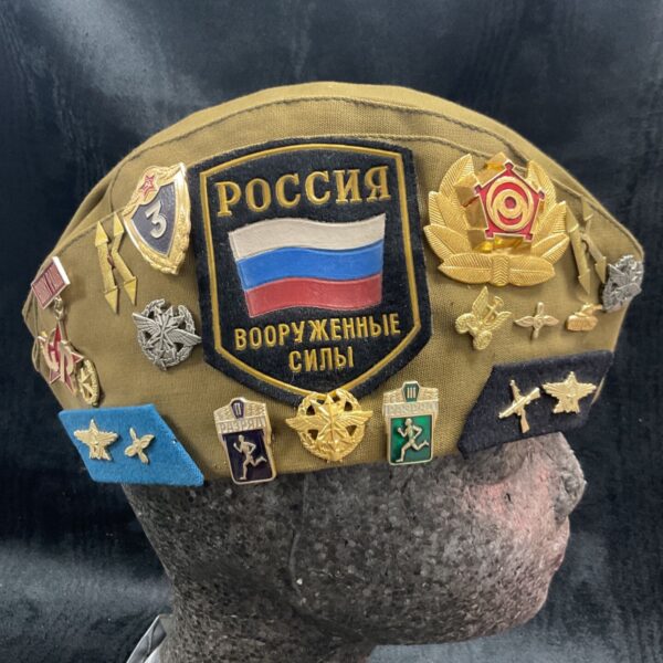 Russian military pilotka hat with badges displayed on a mannequin head.