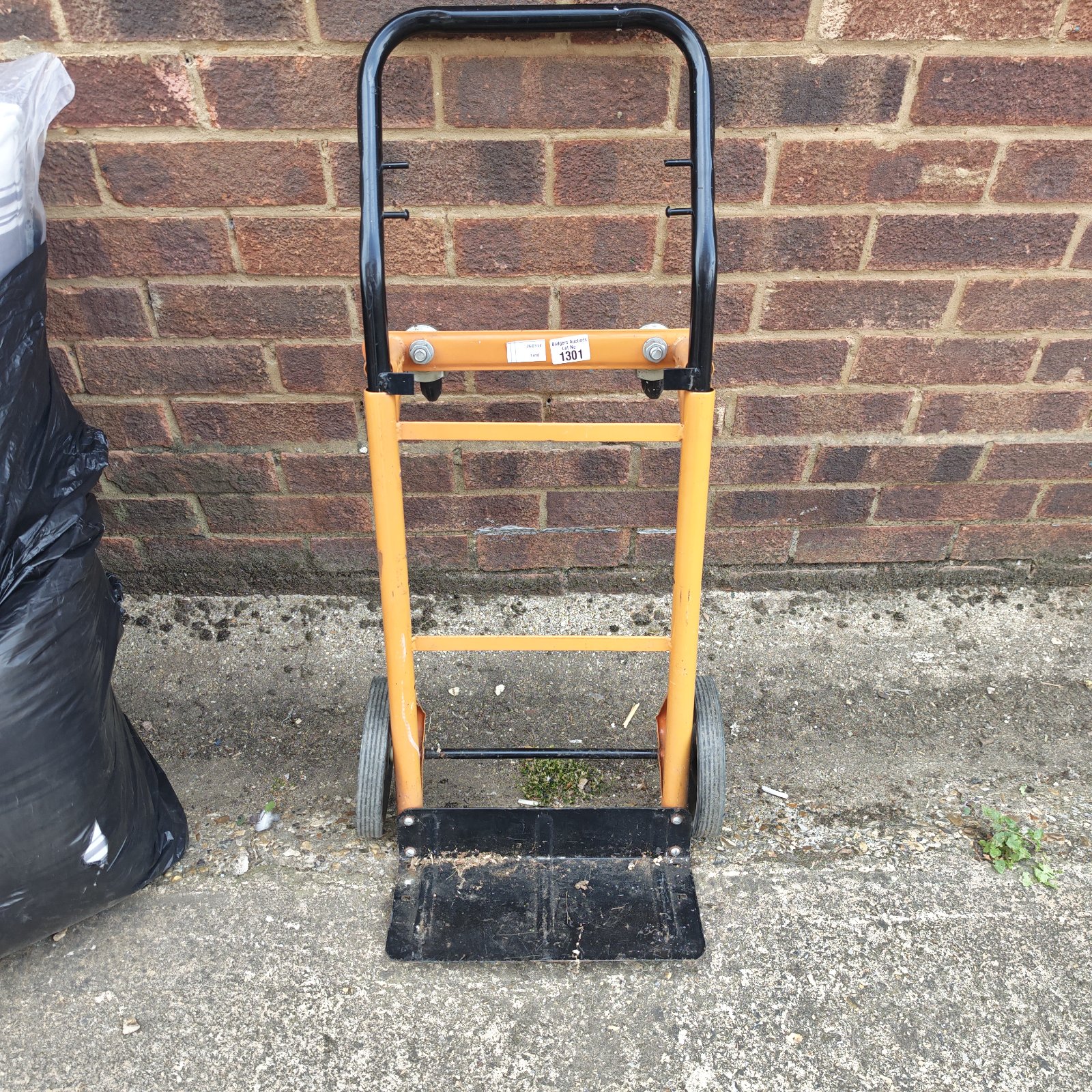 Small sack barrow with steel frame and plastic deck.