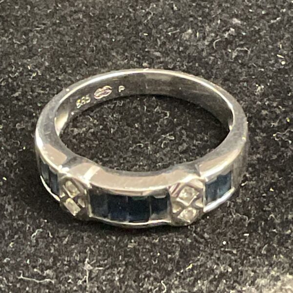 Close-up of a white gold ring with sapphire stones.