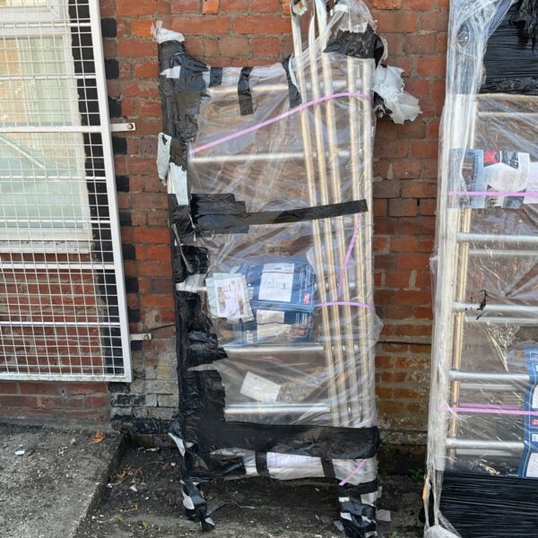 Sealed scaffolding kit wrapped in plastic for construction work.