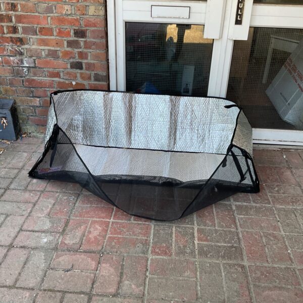Scratch and Newton hutch snuggle cover on brick paving.