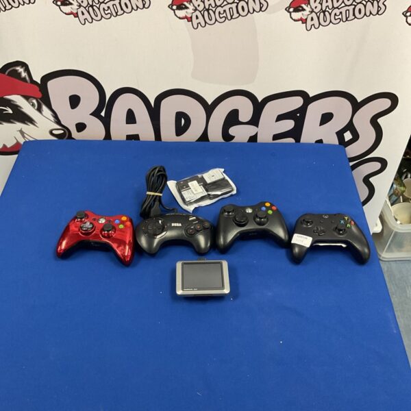 Gaming controller lot including Sega, Xbox, and Garmin GPS device.