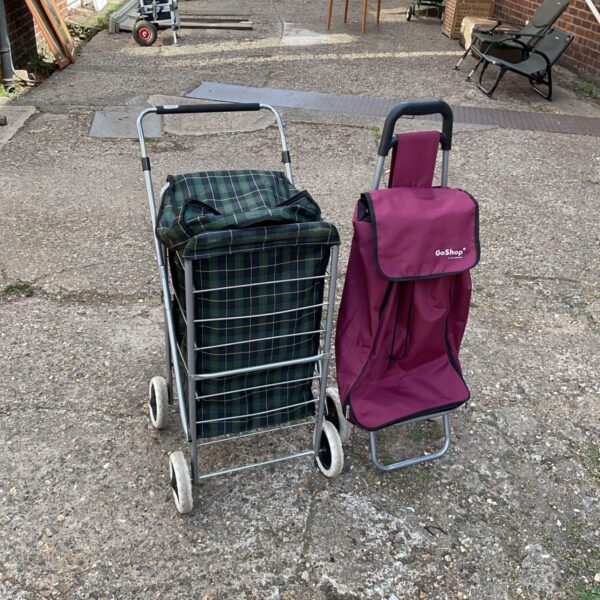 Two folding shopping trolleys, one green and one purple.