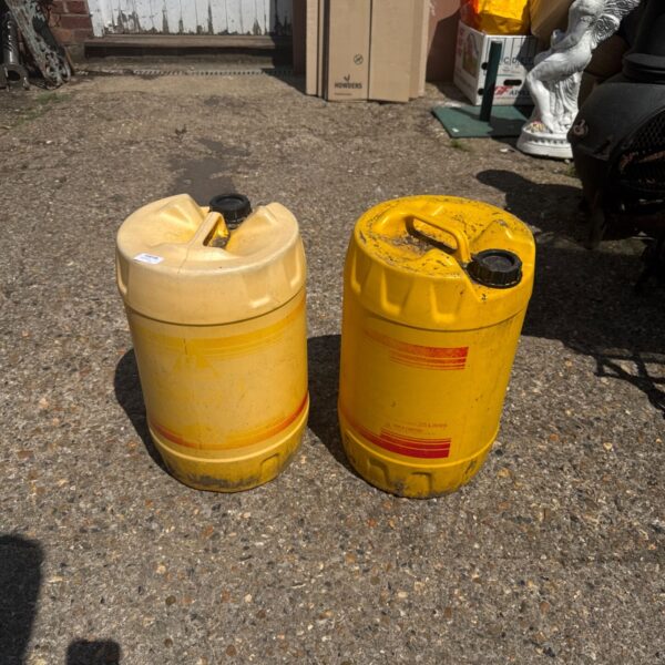 Two yellow 25L Sika Damp Proofer drums for construction projects.