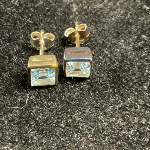 Silver stud earrings with square cut aquamarine gemstones.
