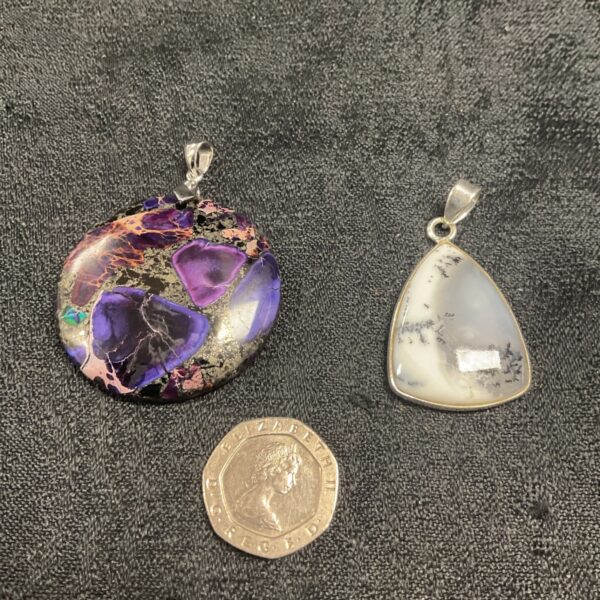 Silver pendants with white buffalo and purple sea sediment jasper gemstones.