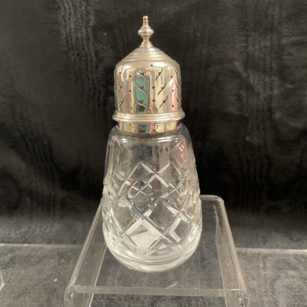 Antique silver topped cut glass sifter with geometric design.