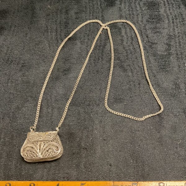 Vintage silver filigree handbag pendant on a delicate chain.