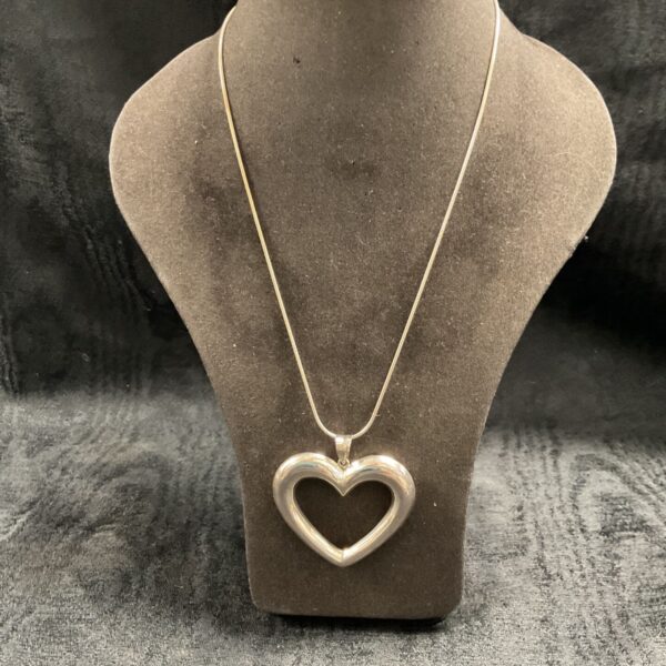 Close-up of silver heart pendant necklace on display.