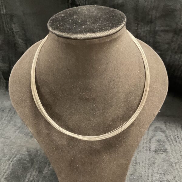 Close-up of silver multi strand choker necklace, vintage style.