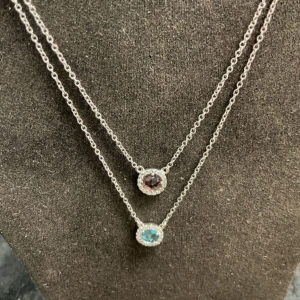 Silver pendant necklaces set with blue and dark coloured stones.