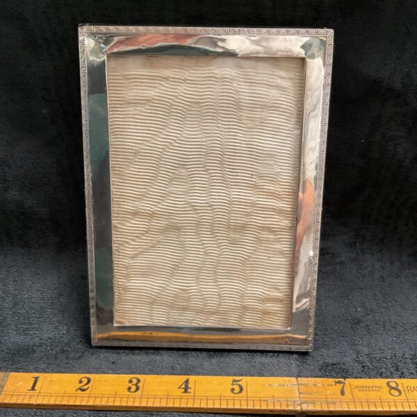 Vintage silver photo frame with embossed detail.
