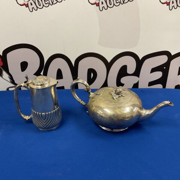 Vintage silver plate teapot and milk jug set with floral details.