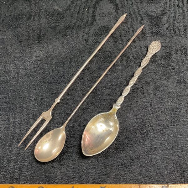 Antique silver spoons and fork set with engraved details.
