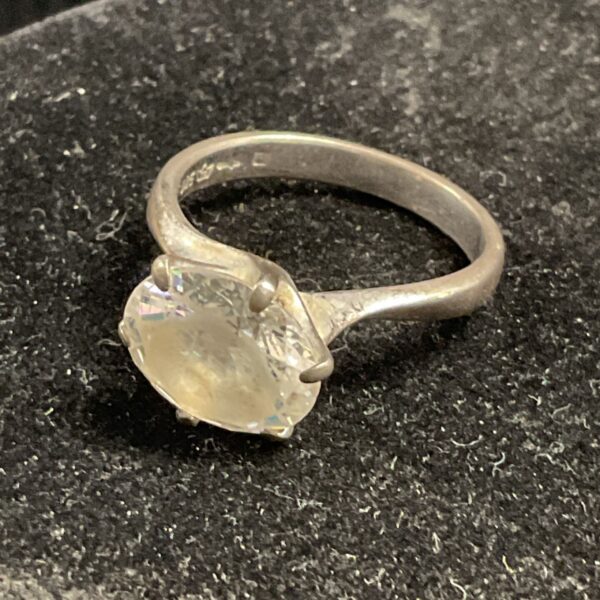 Silver ring with a large white stone, size R.