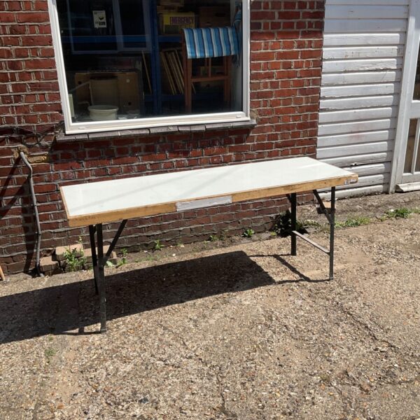 Six foot folding table with metal legs, showing signs of wear.