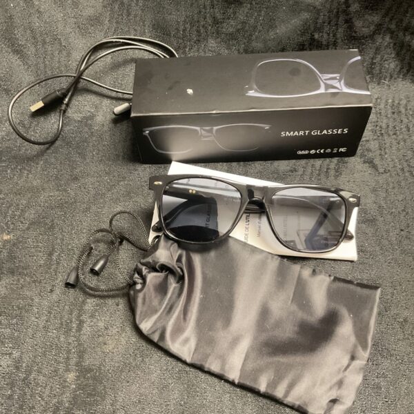Black smart sunglasses with charging cable and instructions included.