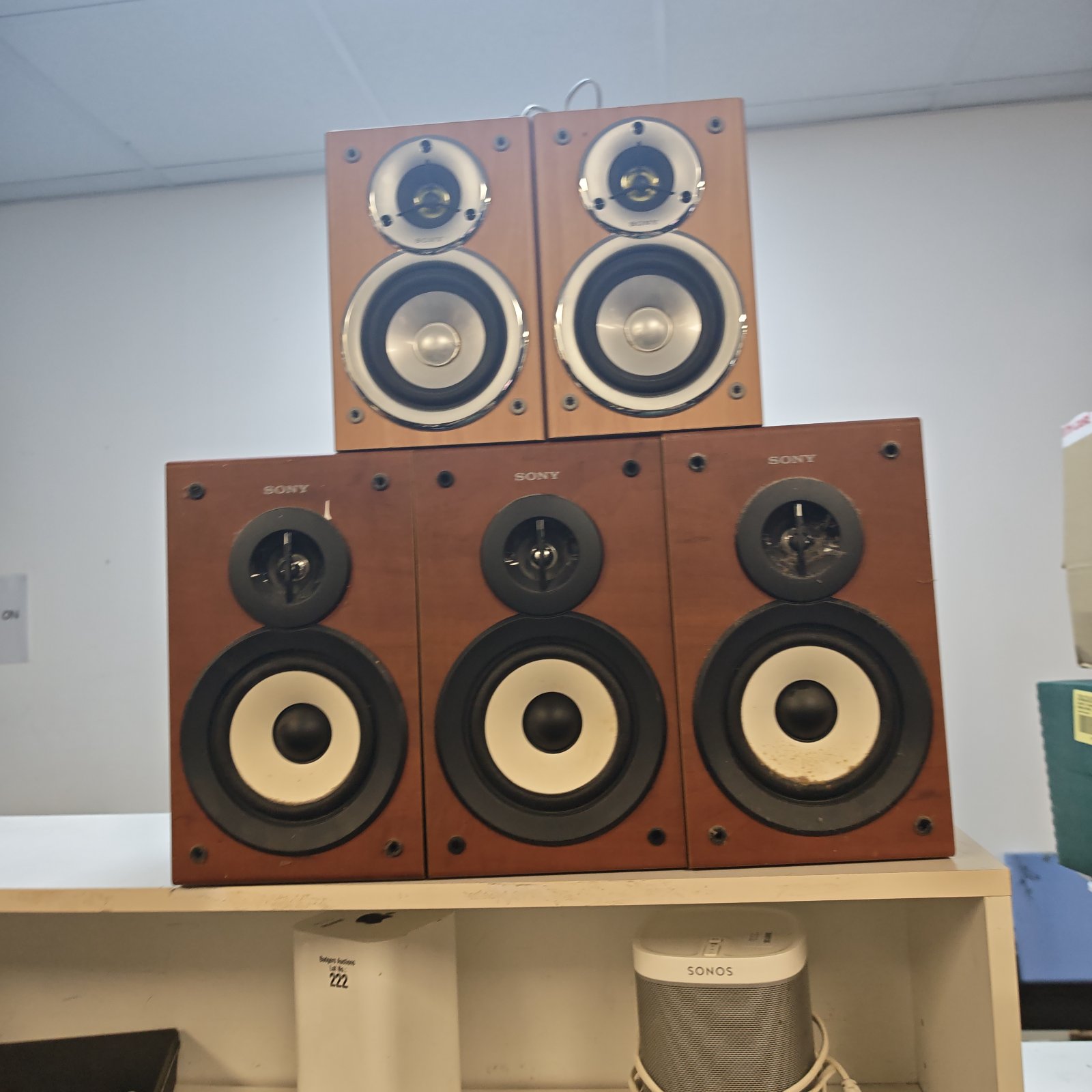 Group of five vintage Sony bookshelf speakers with woodgrain cabinets.
