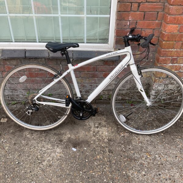 White Specialized Sirrus hybrid bike, side view.