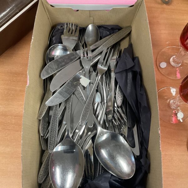 Large stainless steel cutlery set with forks, knives, and spoons.