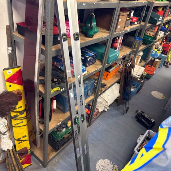 Two Stanley Fatmax spirit levels leaning against shelving.